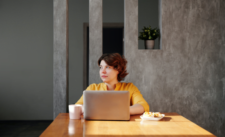 Lonely employee sitting behind laptop not doing anything.